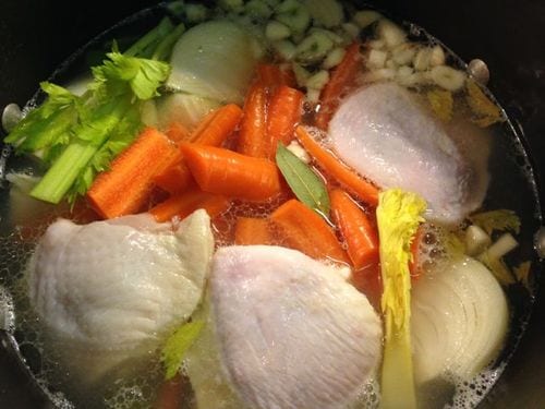 chicken bone broth with carrots and celery in pot