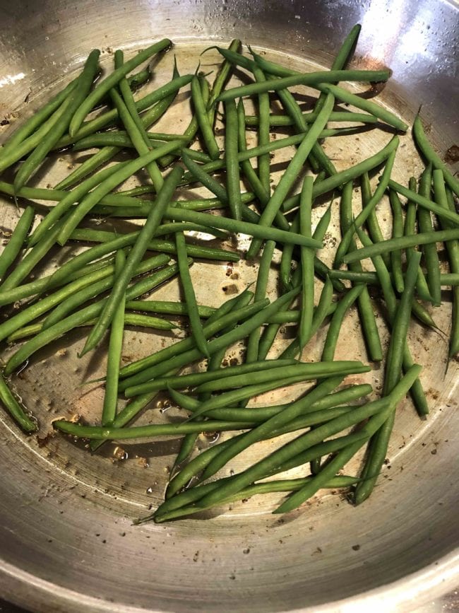 Green beans in frying pan with oil