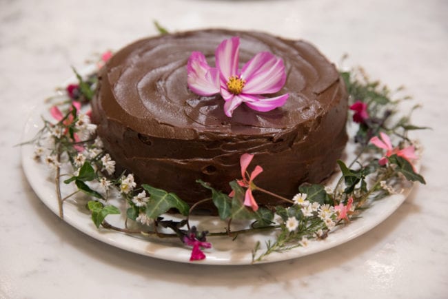 chocolate cake with pink and white flower wreath