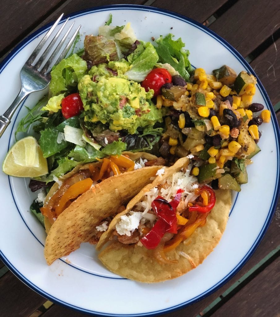 filled crispy gluten free tacos on plate with guacamole, 