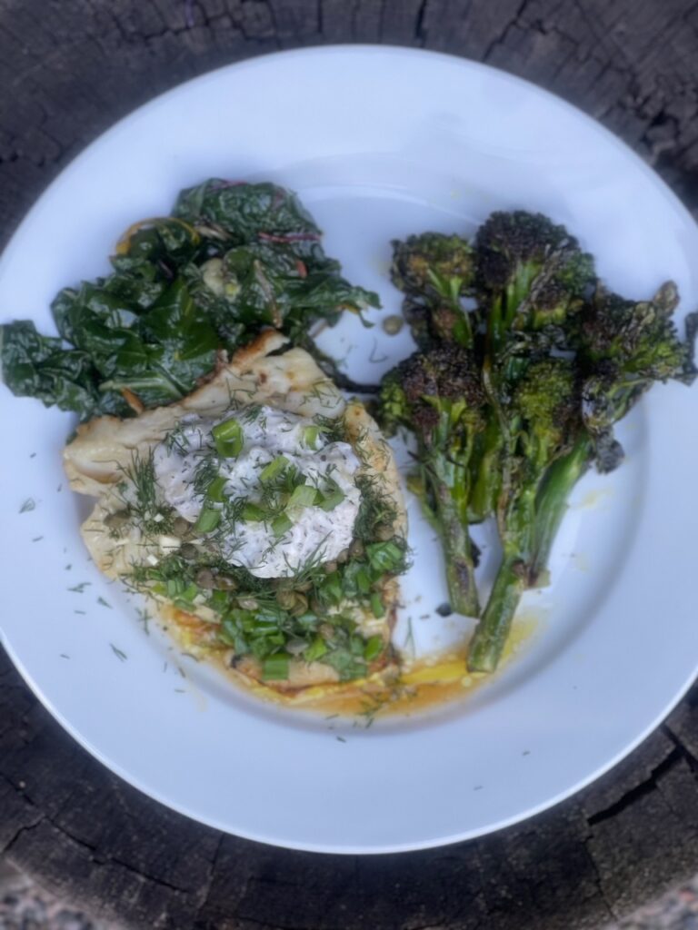 Black Cod on white plate with cooked broccoli