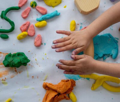 Colorful play dough with Childs hands rolling out the dough