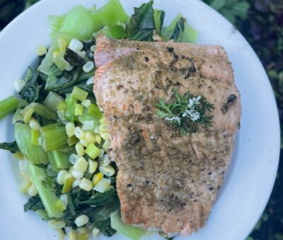 cooked salmon and bok choy salad on a white plate