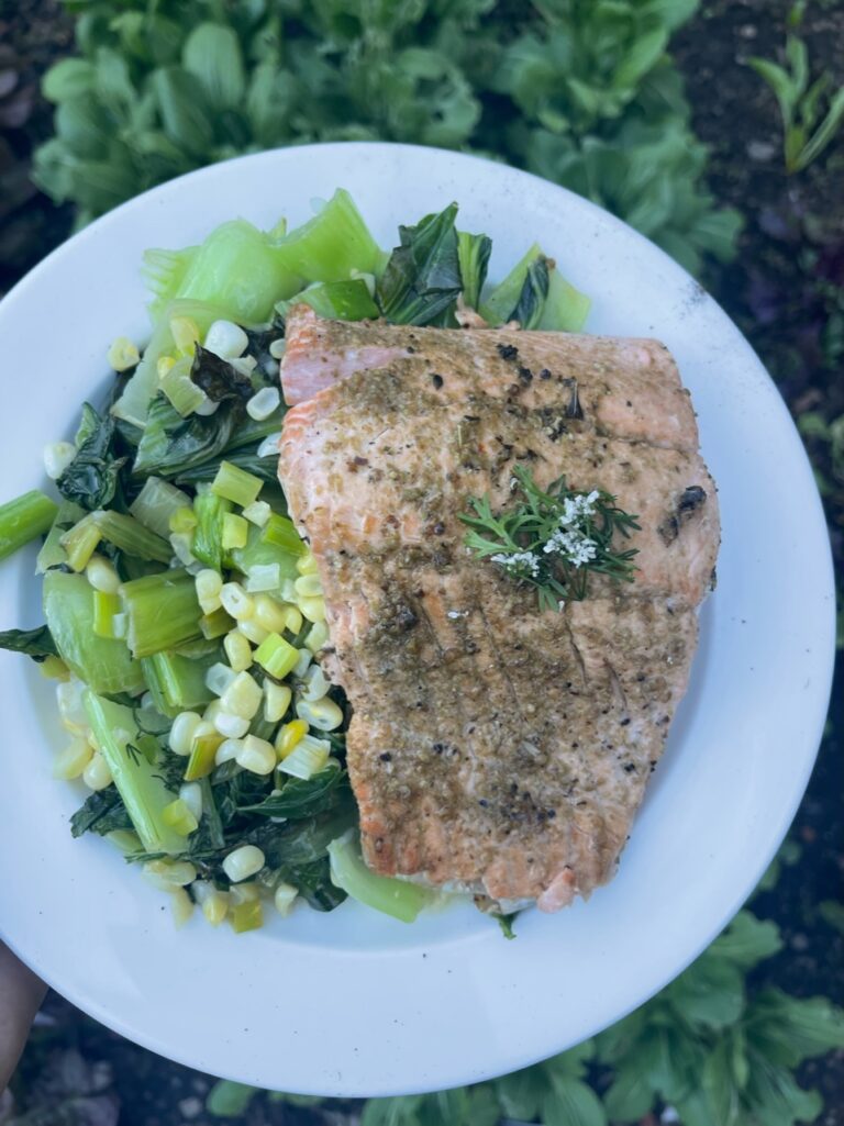 cooked salmon and bok choy salad on a white plate