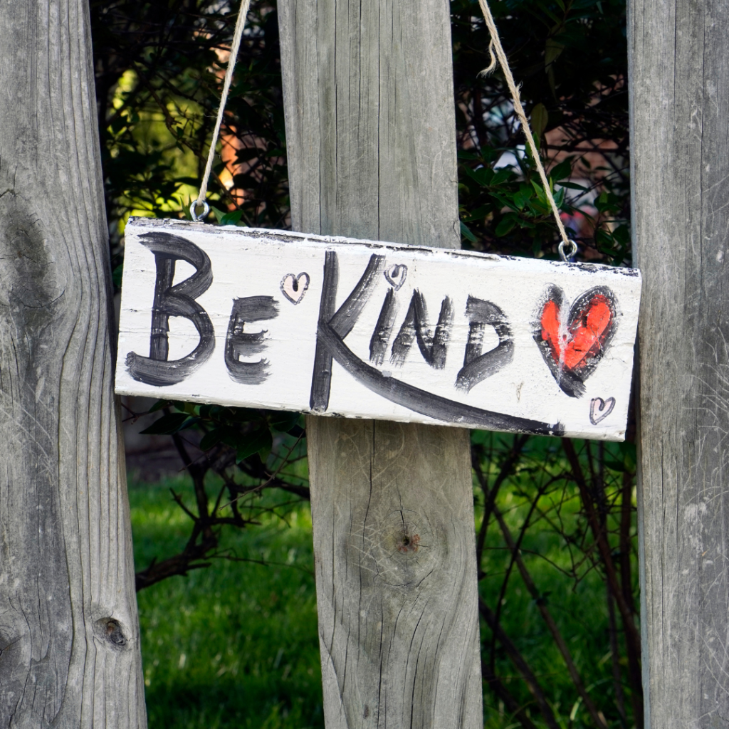 Be Kind sign on a wood fence